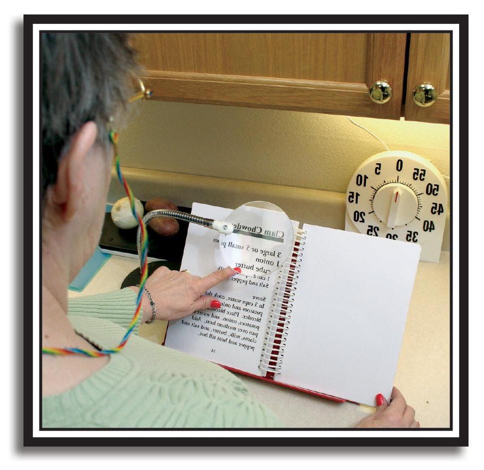 photo of woman in kitchen reading a recipe using a magnifier