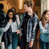 photo of diverse students in school hallway talking between classes